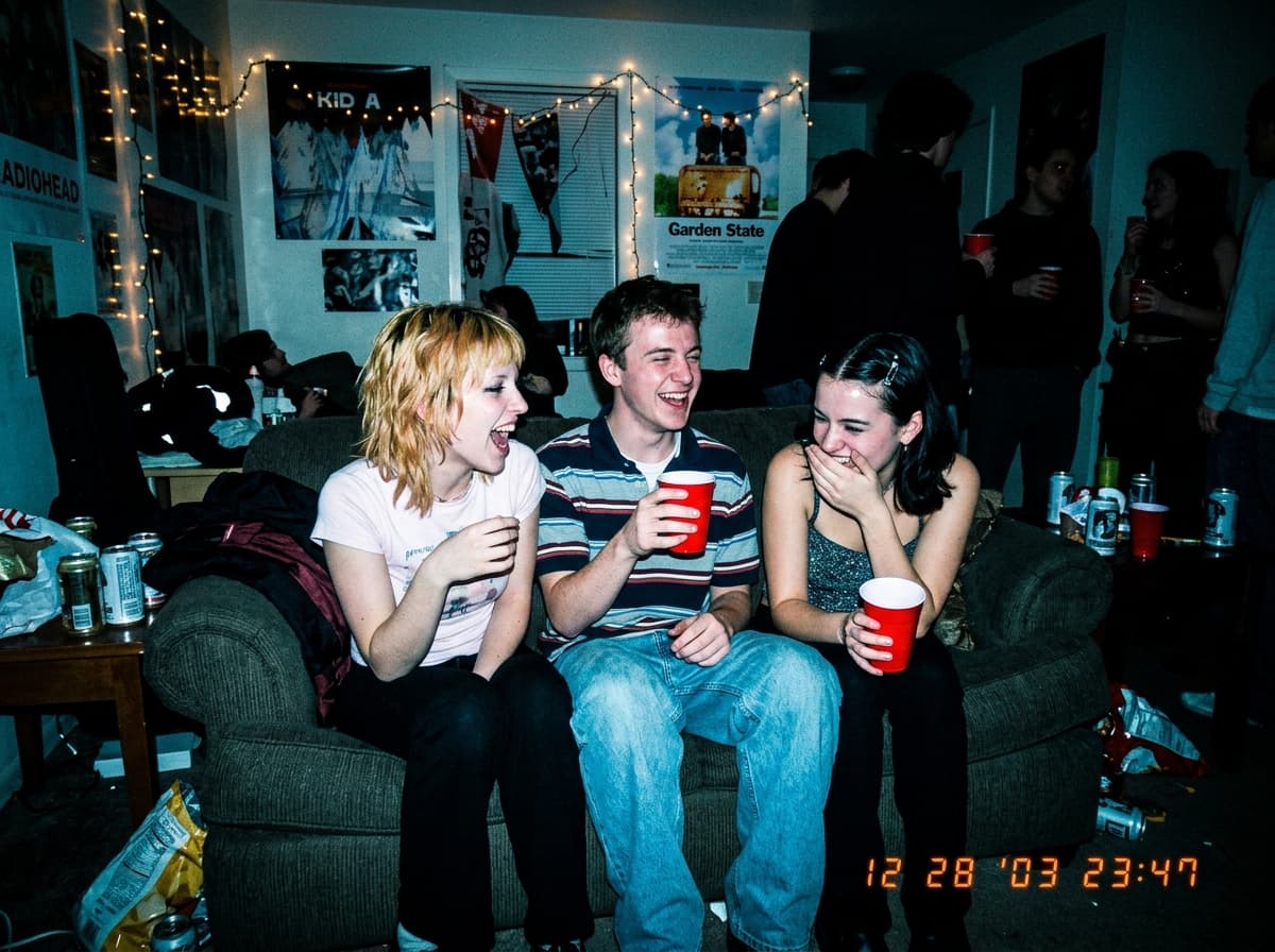 Y2K house party photo with overblown flash and date stamp